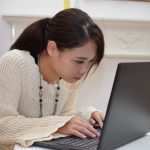 パソコンに集中して猫背になる女性