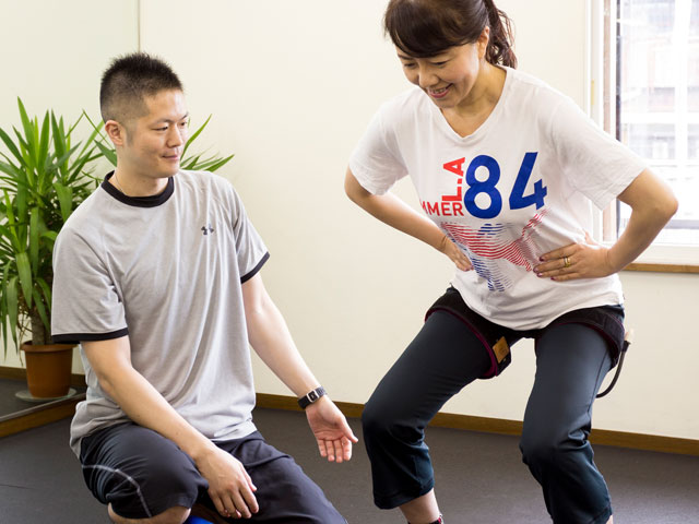 加圧トレーニングをしている女性とトレーナー