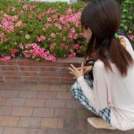 花壇のそばでヤンキー座りをしている女性