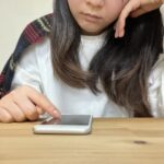 スマホをいじる女性