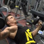 インクラインダンベルプレスをする男性